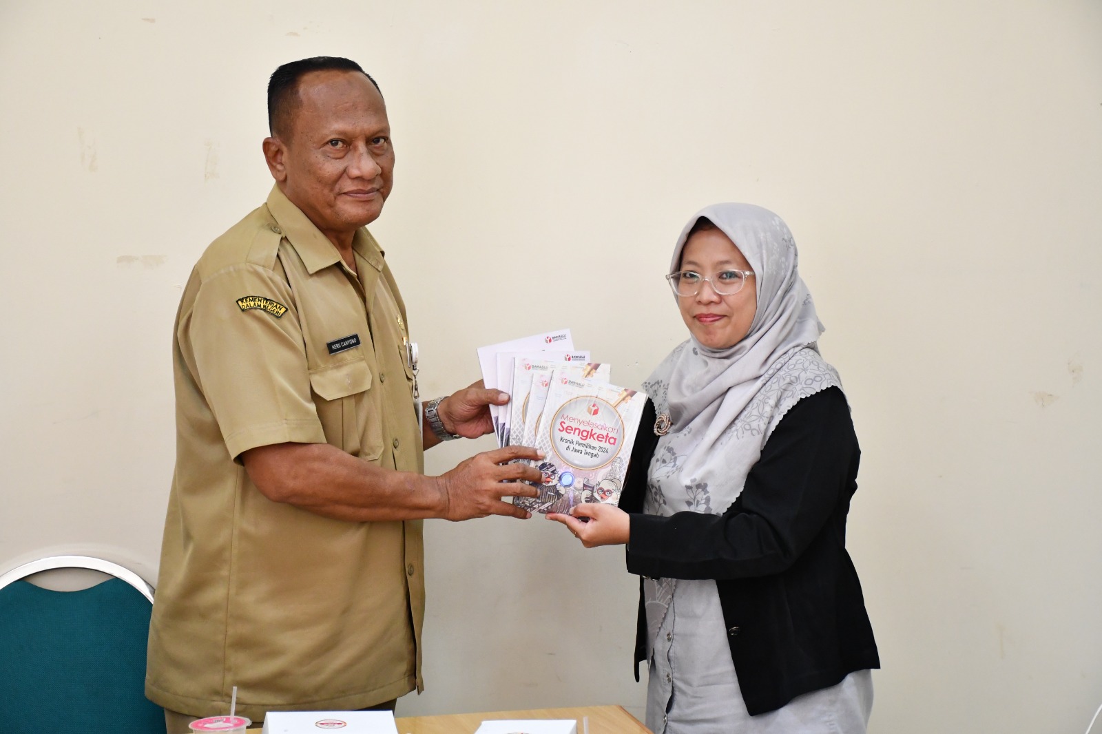 Anggota Bawaslu Kabupaten Semarang, Ummi Nu'amah memberikan literasi buku kepada Kepala Dinas Arpus Kabupaten Semarang, Heru Cahyono dalam kegiatan Audiensi Bawaslu Kabupaten Semarang, Selasa 21 Oktober 2025